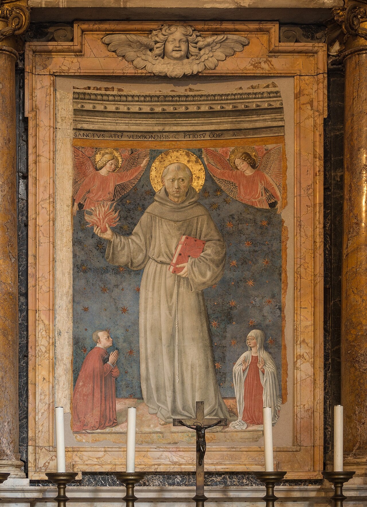 Fresco que representa a San Antonio de Padua vistiendo hábito franciscano y sosteniendo un libro y una llama en su mano.