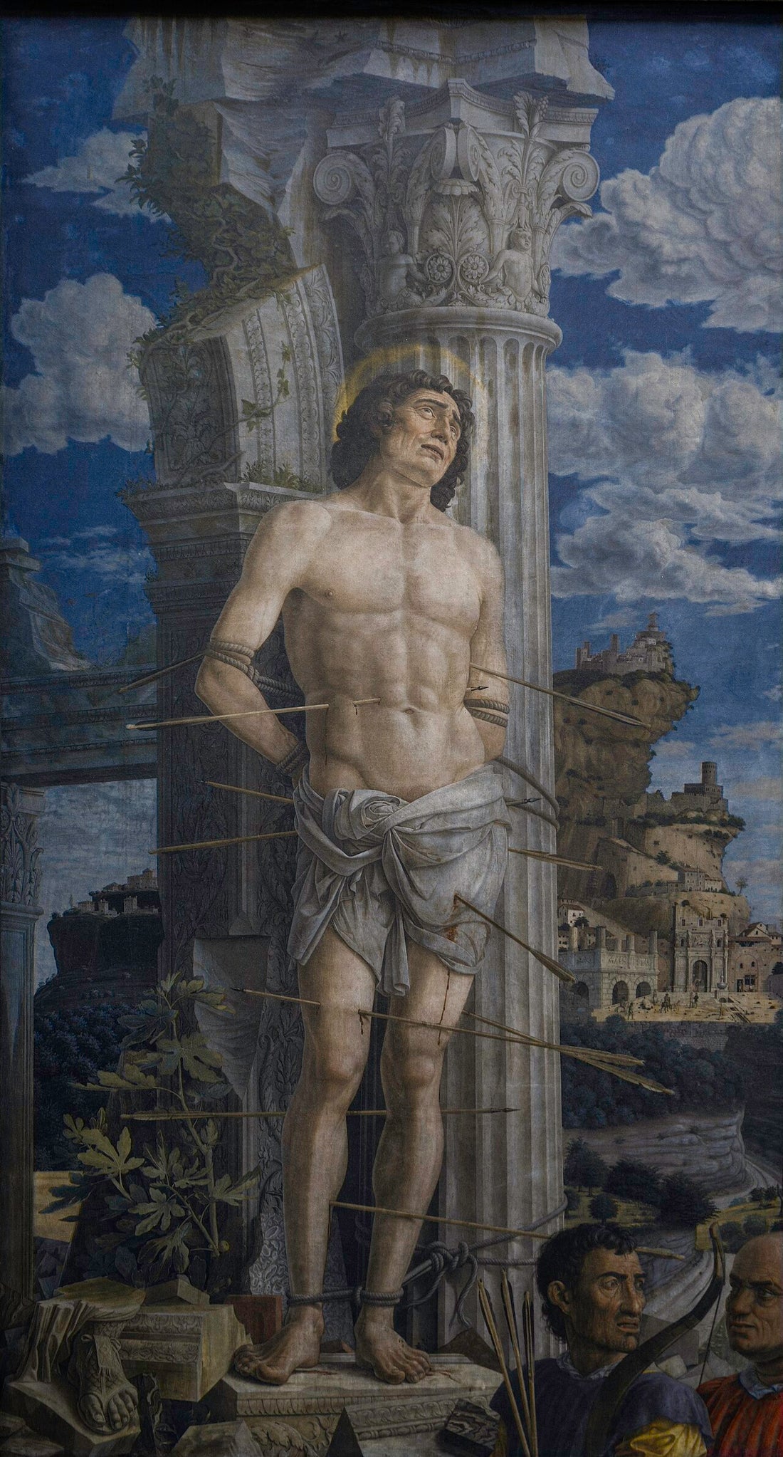 Pintura de San Sebastián atado a una columna clásica en ruinas con flechas clavadas en su cuerpo, ante un paisaje arquitectónico.