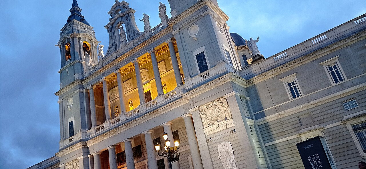 Fachada principal iluminada de la Catedral de la Almudena de Madrid al anochecer