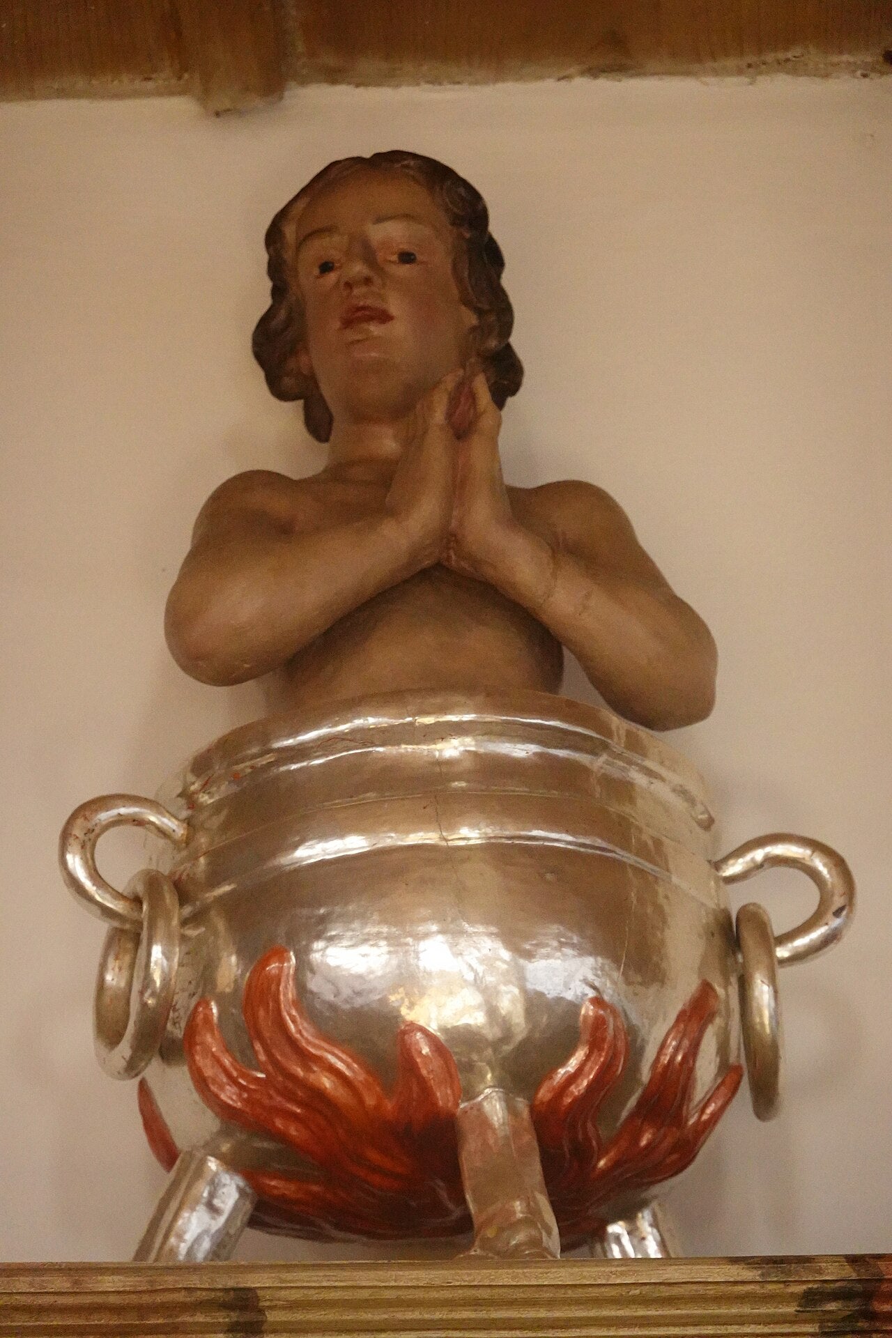 Representación artística de San Vito en el caldero de aceite.