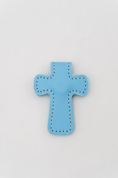 Marcapáginas magnético azul claro con forma de cruz y costura perimetral en color blanco.