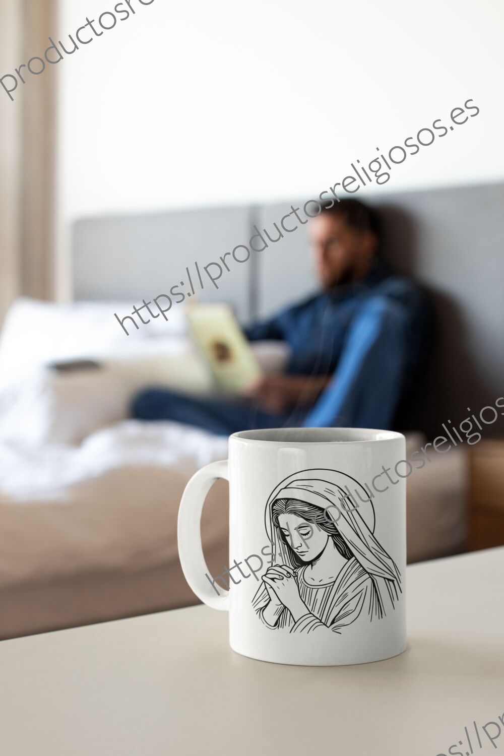 Taza blanca con dibujo religioso sobre una mesa blanca en un dormitorio luminoso.