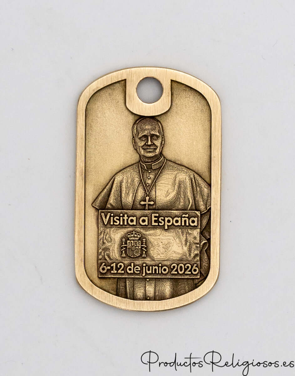 Detalle frontal de placa conmemorativa de latón con la inscripción Visita a España junio 2026.