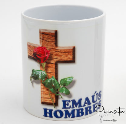 Detalle de impresión en taza blanca con texto Emaús Hombres y cruz decorativa.